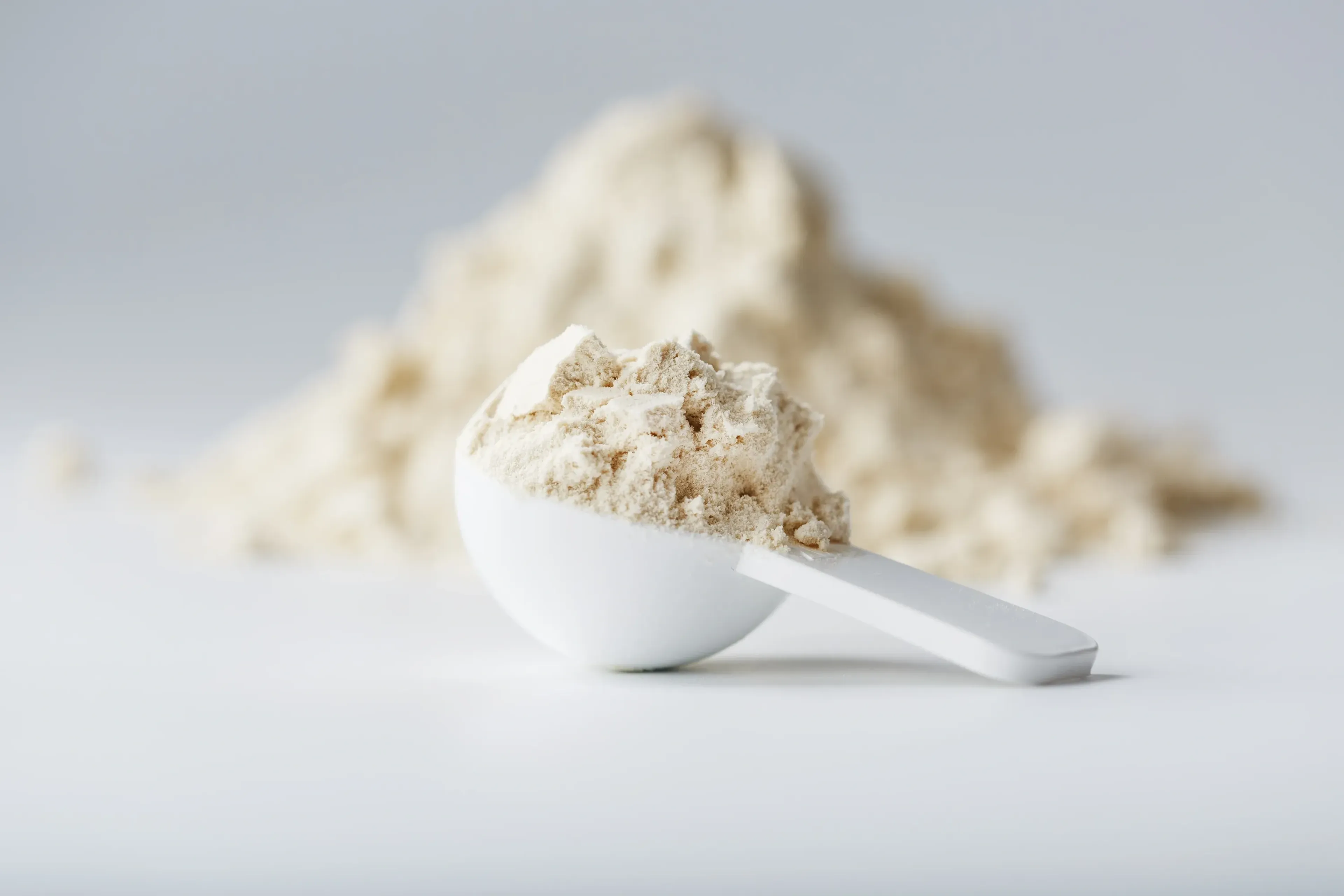 A mountain of protein powder with a measuring spoon